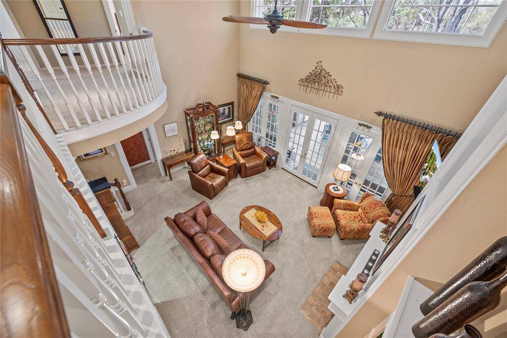 View from the second-floor balcony overlooking the living room, highlighting the soaring high ceilings and elegant design. The open layout enhances the grandeur of this luxurious living space.