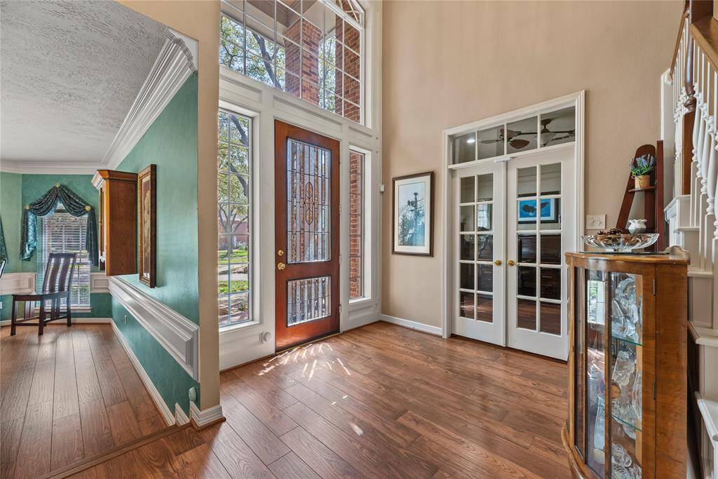 Welcoming entryway features high ceilings and abundant natural light from large windows. Upon entry, on the right is the dining room.