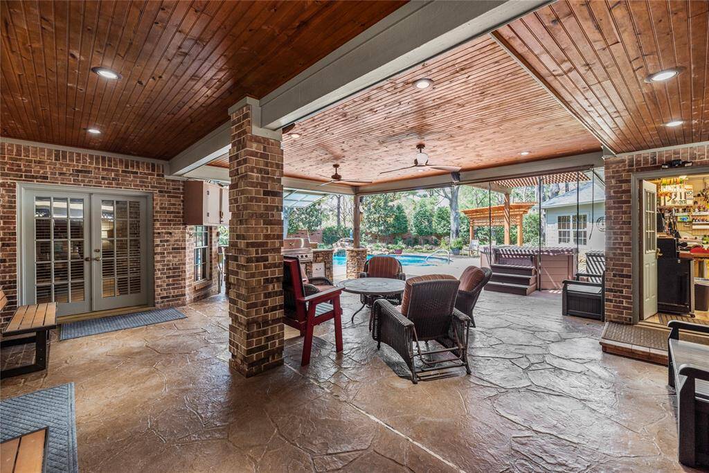 Alternate view of the backyard covered patio where you can view the pool area. This is perfect for entertaining and relaxation.