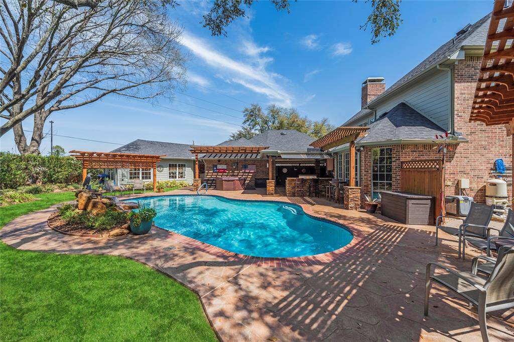 Spacious in-ground pool in the backyard surrounded by a well-maintained patio. There are pergolas for shade. Perfect for entertaining and relaxation.
