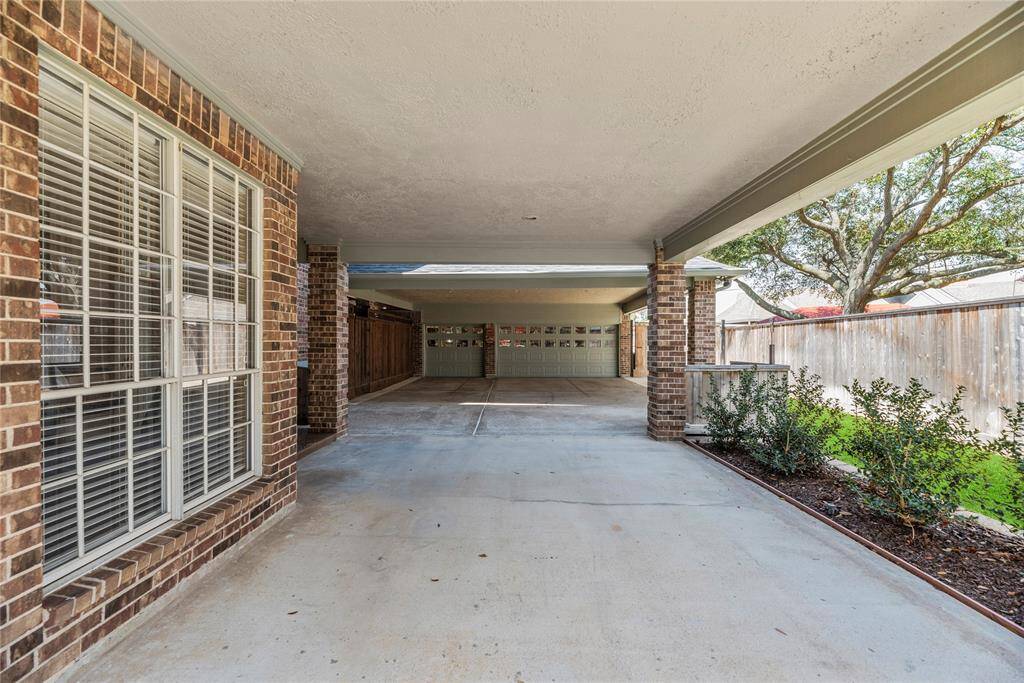 Spacious covered driveway leading to the garage, providing additional parking space and versatility for storage, outdoor projects, or recreational use.