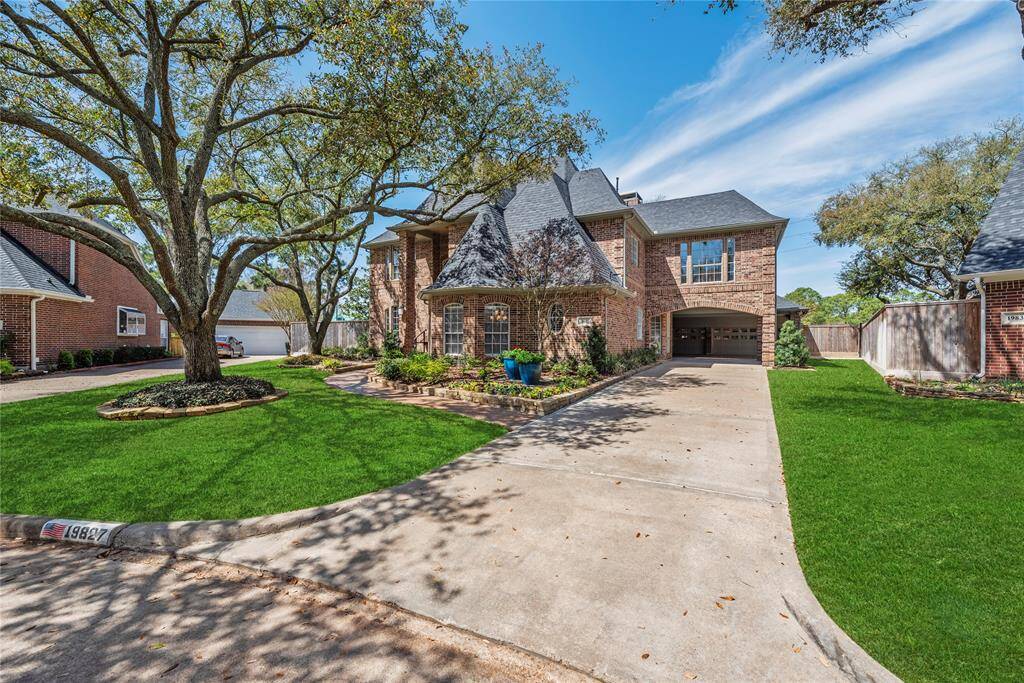 Front of the home featuring the spacious driveway leading to the two-car garage.