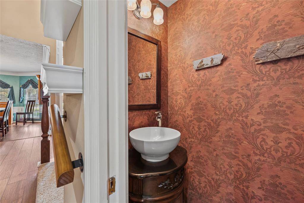 Powder room with a stylish vessel sink on a vintage vanity.