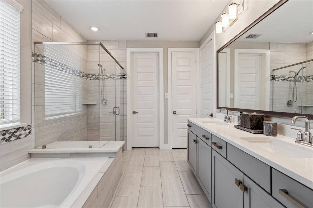 Beautiful primary bathroom with dual sinks, separate tub and shower, and stylish finishes.