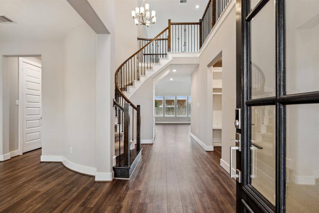 Upon entering, you are greeted by two story ceilings, gleaming luxury vinyl flooring, walls of windows, and modern high-end finishes.