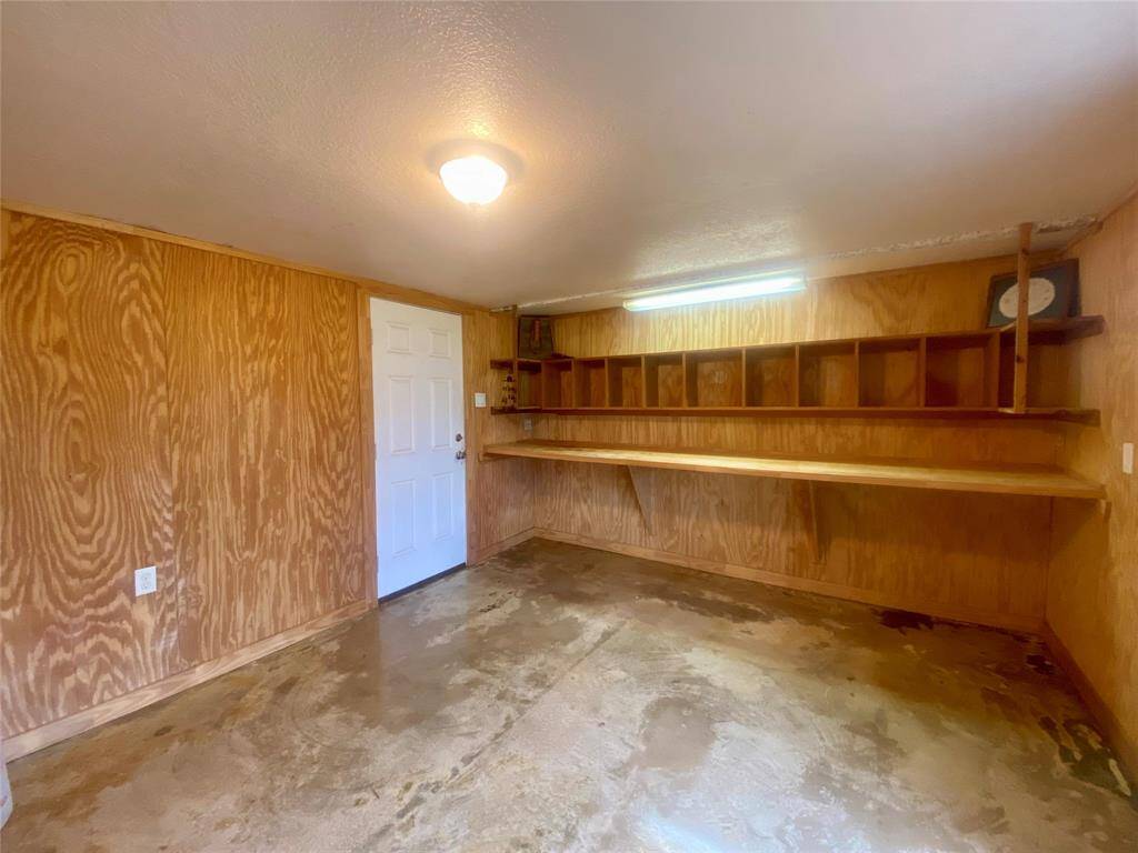 Another view of the office space with built in shelving. Door to the left leads to the 2+ car tandem garage.