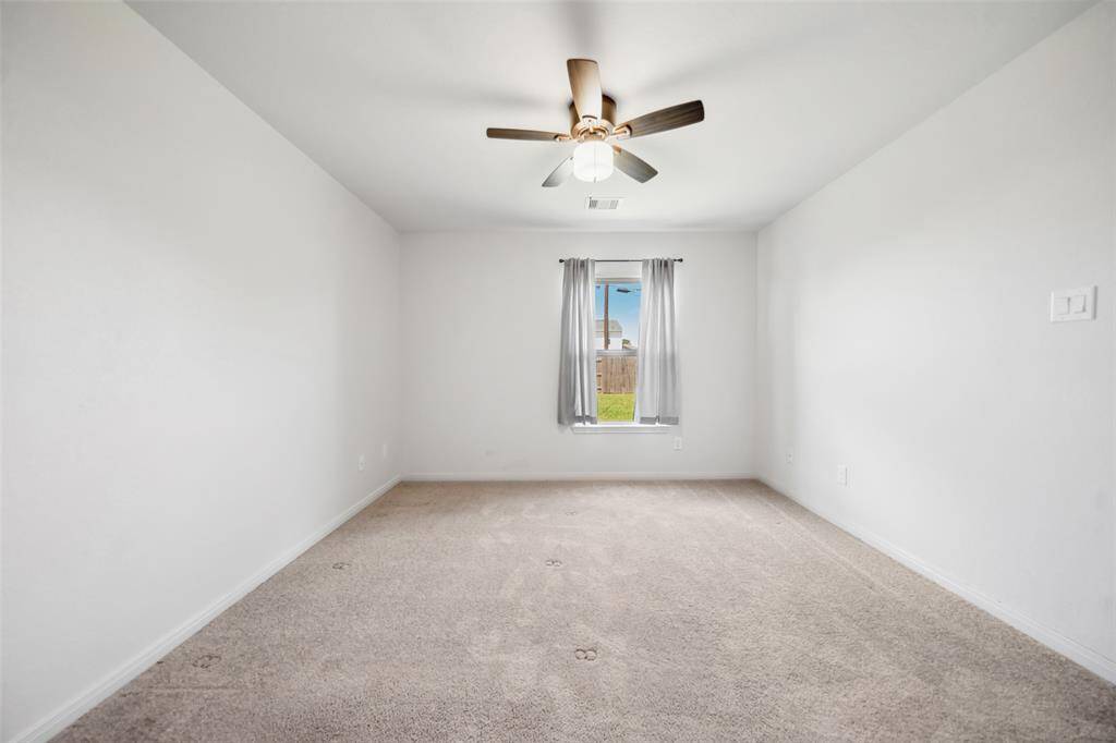 Generously sized bedroom with ceiling fan, large window, and neutral carpet—ready to be styled to your taste.