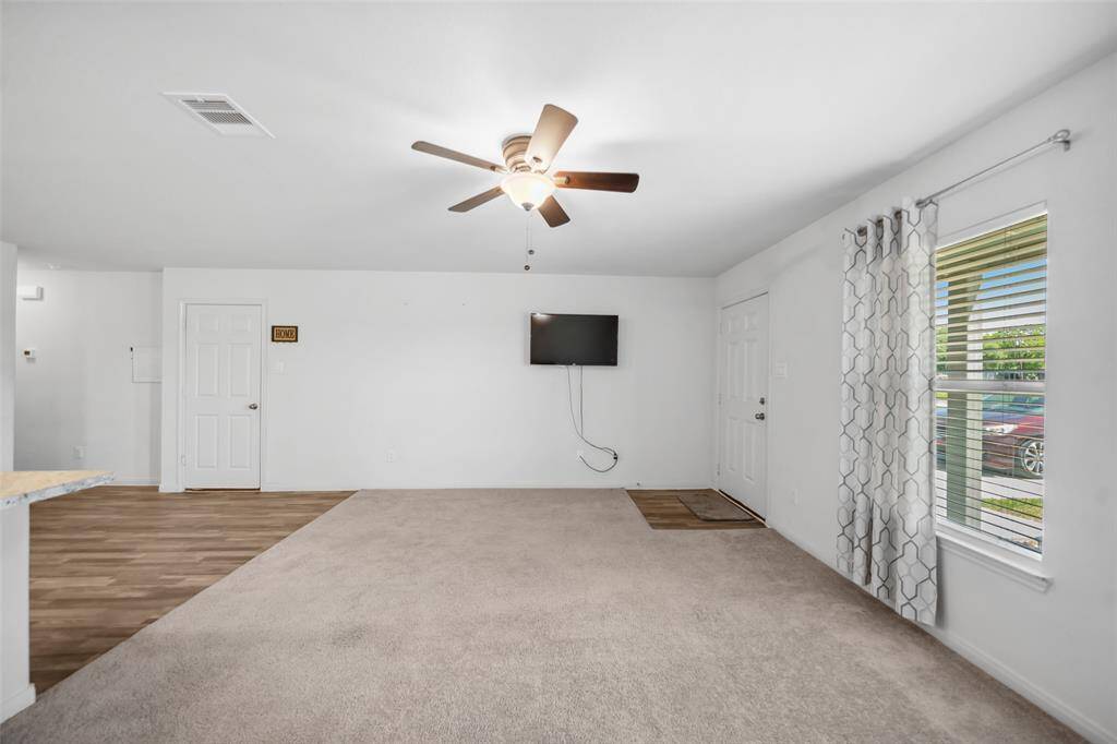 Another angle showcasing the living room’s natural flow and abundant light. The neutral tones provide a perfect canvas for any decor style.