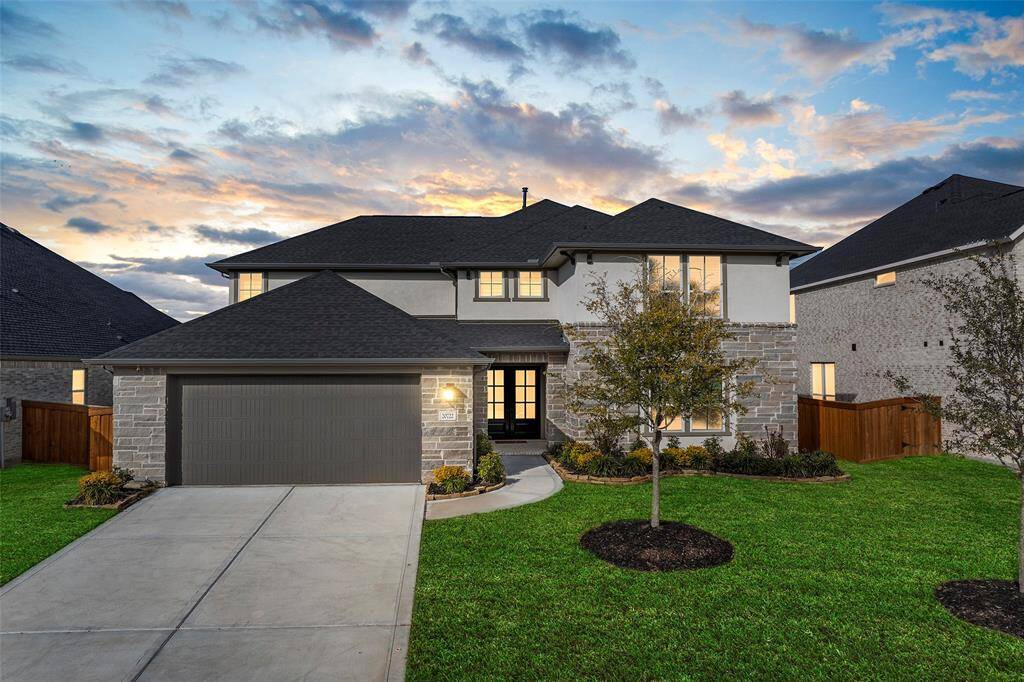 Striking curb appeal for this exceptional two-story home in Cypress. A blend of stone and stucco exterior, architectural rooflines, and a wide driveway create a sophisticated first impression. The double front doors open to a thoughtfully designed interior, while manicured landscaping and uplighting highlight the home's elegant facade. Located in a desirable master-planned community, this residence combines modern style with everyday comfort from the moment you arrive.