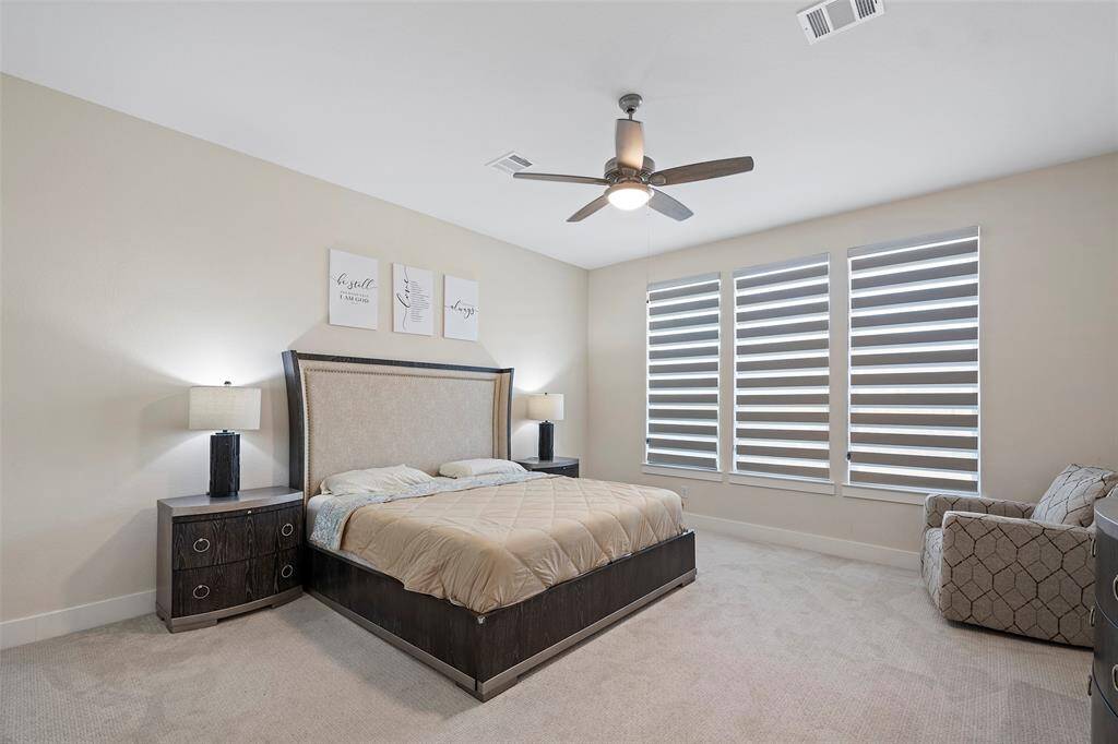 Tucked away for privacy, the first-floor primary bedroom offers generous proportions, soft neutral tones, and ample natural light—creating a peaceful place to unwind at the end of the day.
