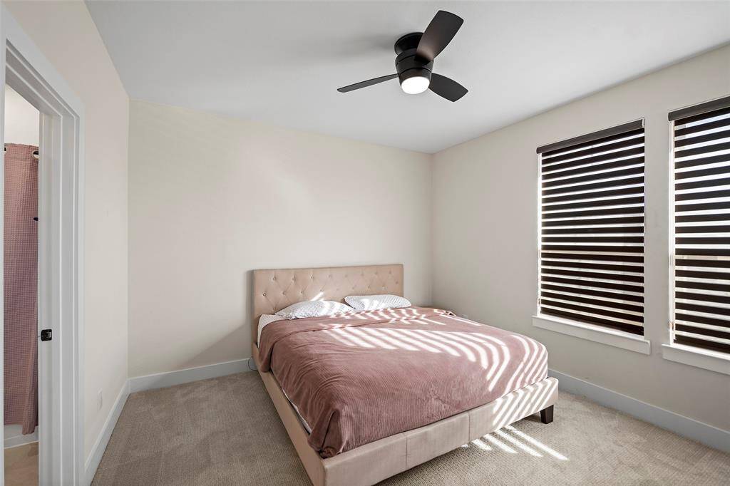Secondary bedroom located upstairs features soft neutral tones, plush carpet, and ample natural light. Positioned near a full bathroom, it offers privacy and comfort for guests or family members.