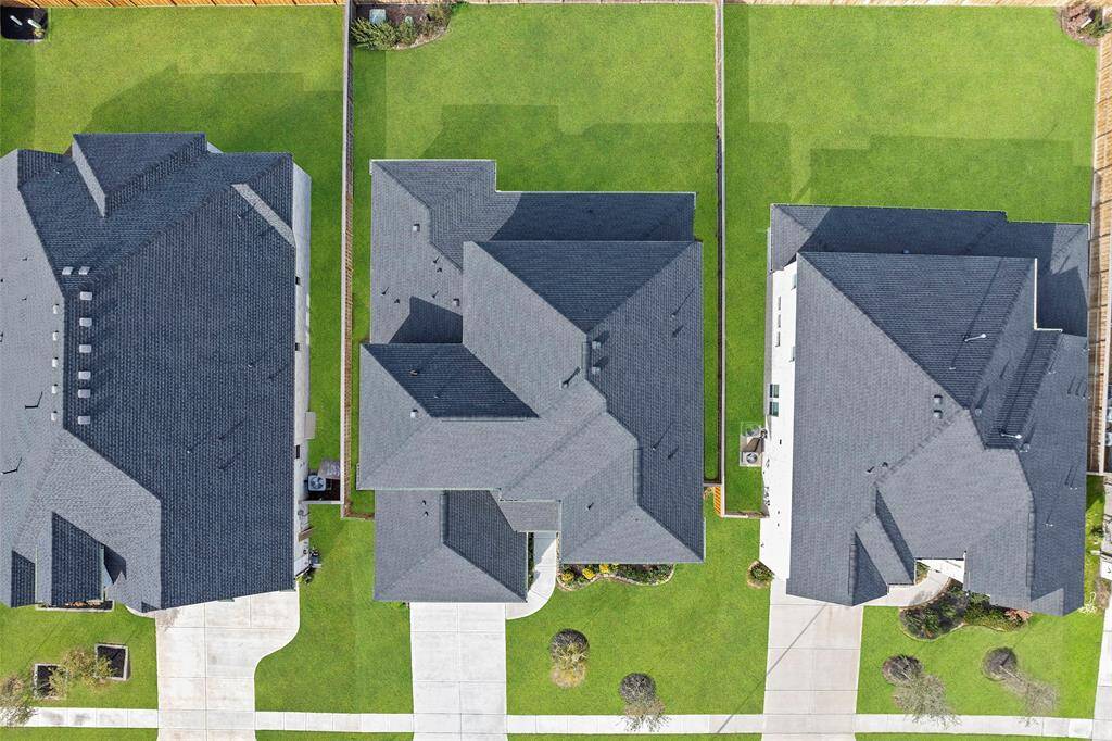 This aerial view highlights the full property layout, showcasing the generous lot size and well-maintained backyard space. With ample room on either side and behind the home, the lot offers flexibility for future enhancements like a pool, garden, or play area—perfect for enjoying outdoor living year-round.