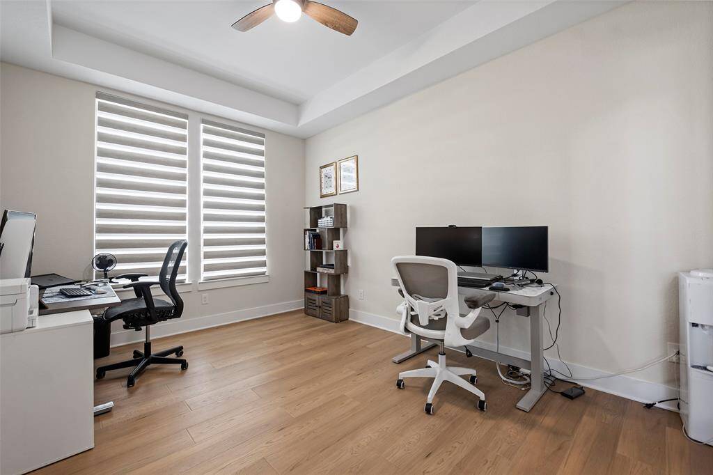 Tucked behind double glass doors, the home office is thoughtfully designed with tray ceilings, wide-plank floors, and generous natural light—creating a polished and productive space for work or study.