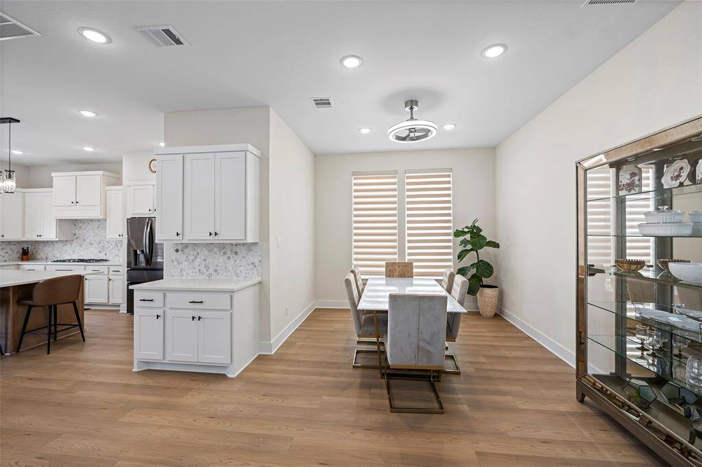 The dining room sits just off the kitchen, offering a defined yet connected space for hosting. Dual windows add natural light, while the built-in hutch wall allows for elegant storage or display.