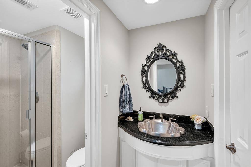 This full bathroom with shower and decorative sink is located off the loft/bedroom.