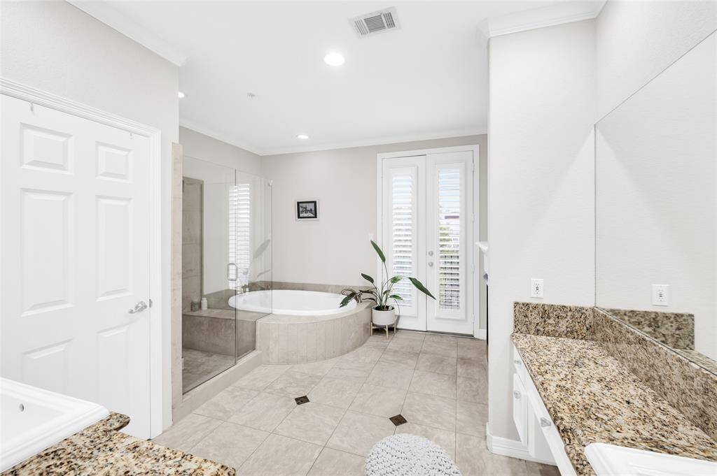 Another angle of the primary suite bathroom with the large jetted tub, double sink vanity, and the spacious standing shower.