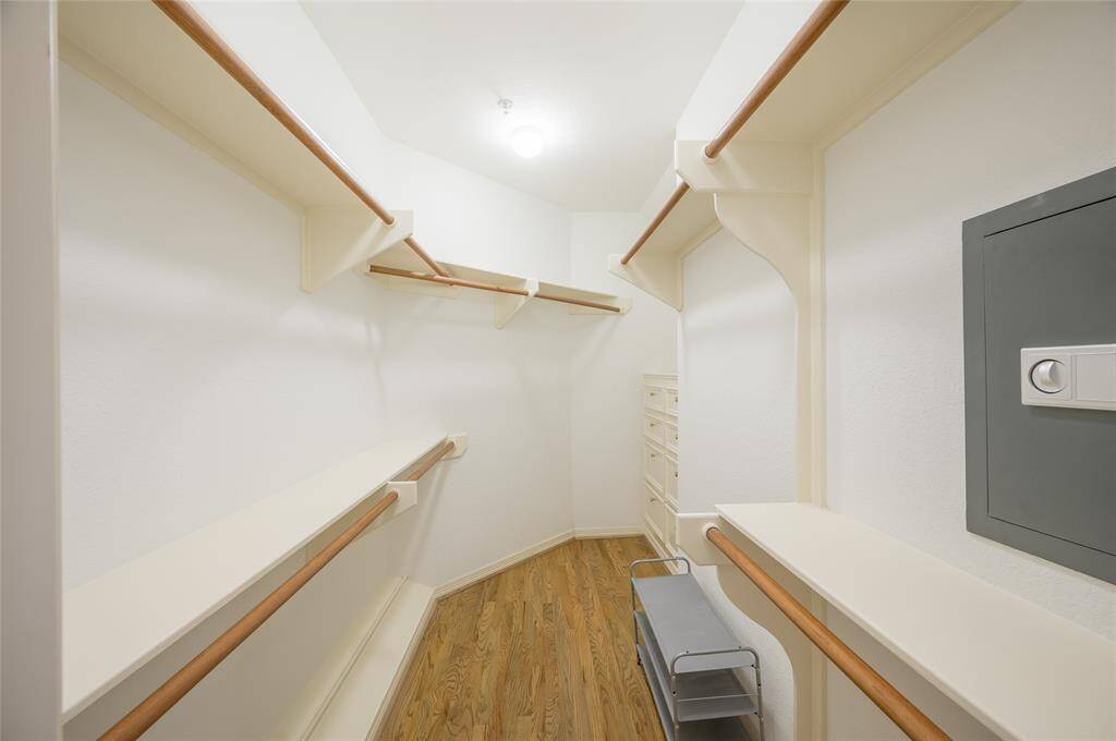The second walk-in closet offers hanging space and eight drawers of storage. Note the built-in safe to the right.