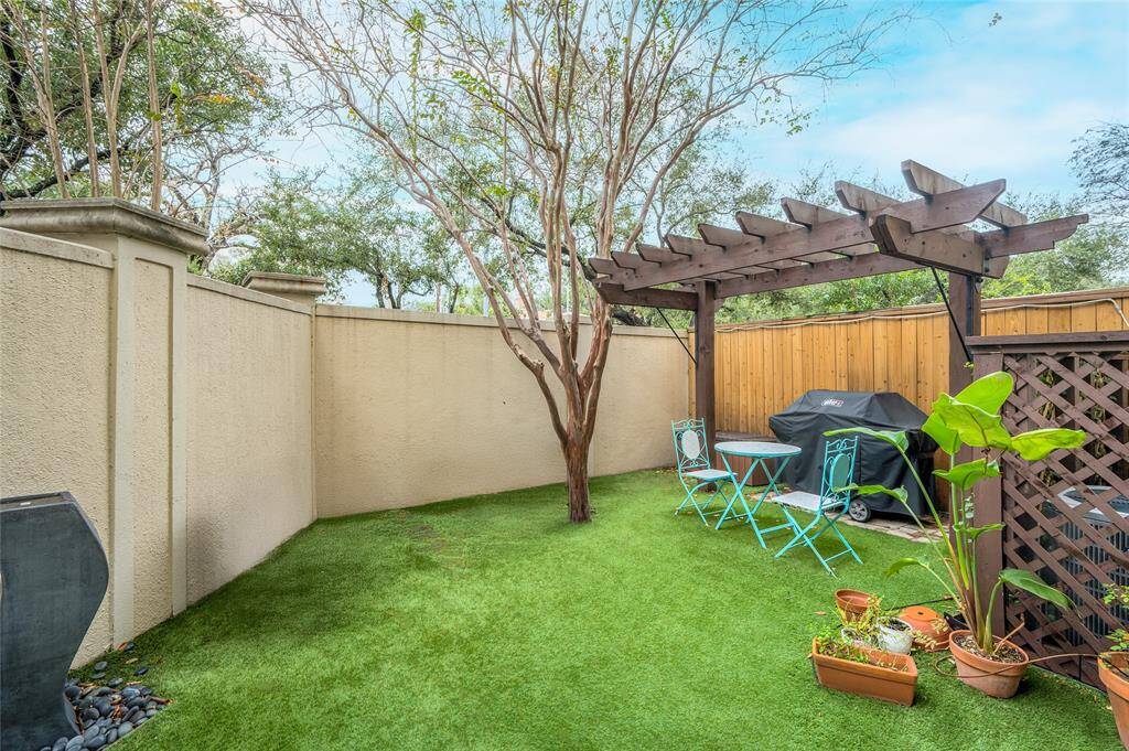 The nice backyard offers plenty of greenspace for play and pets! The gas grill and fountain convey with the home.