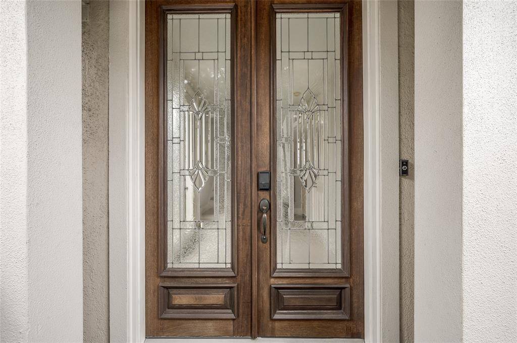 The custom front doors are accentuated by intricate beveled glass design.