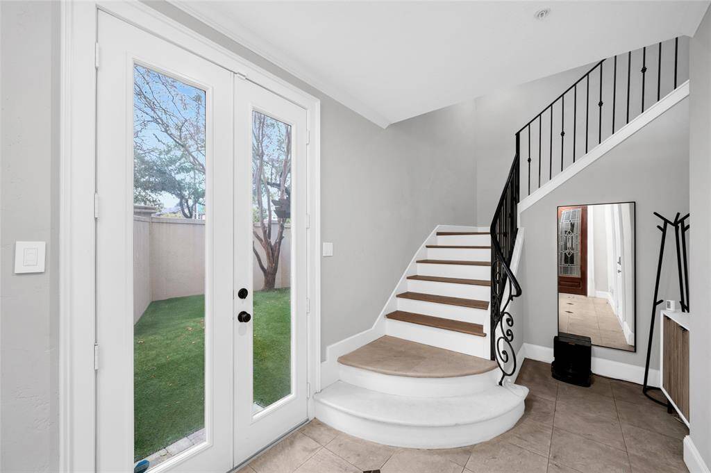 The entry features marble floors with enlays, French doors to the pretty yard, and garage entry.