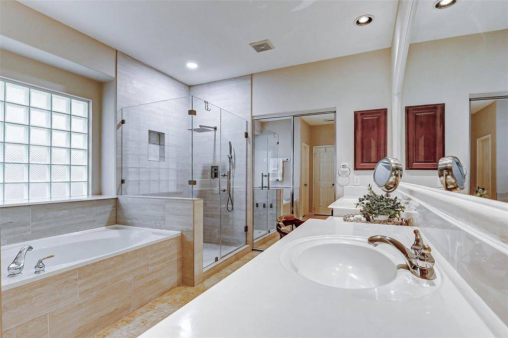 Primary Bath with recent updates. Behind the double mirrored sliding doors is a HUGE walk-in closet.