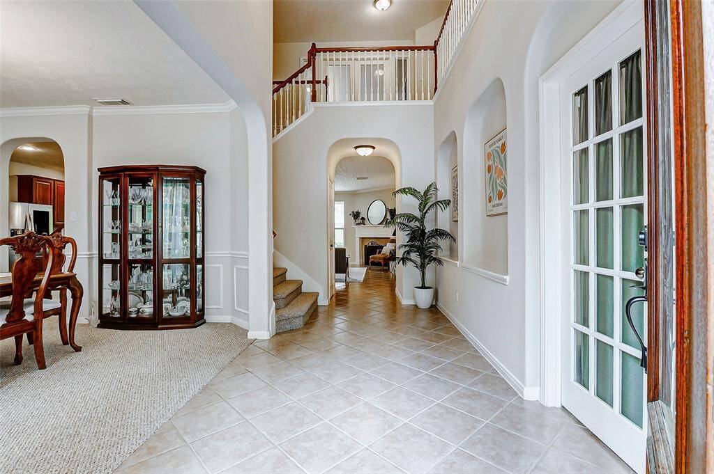 Upon entry there is a formal dining on the left and office space on the right. The stairs cascade to the left and right of the wall behind the china cabinet in the picture and there is a large under the stairs storage.