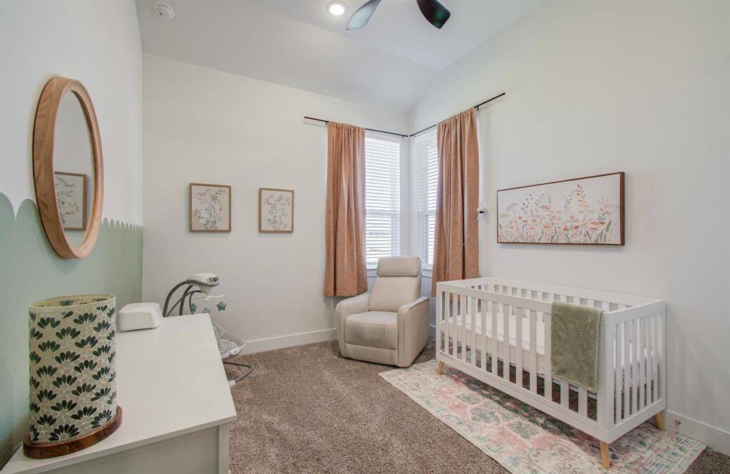 Charming secondary bedroom with a spacious layout, high ceiling, closet space, and views of the backyard.