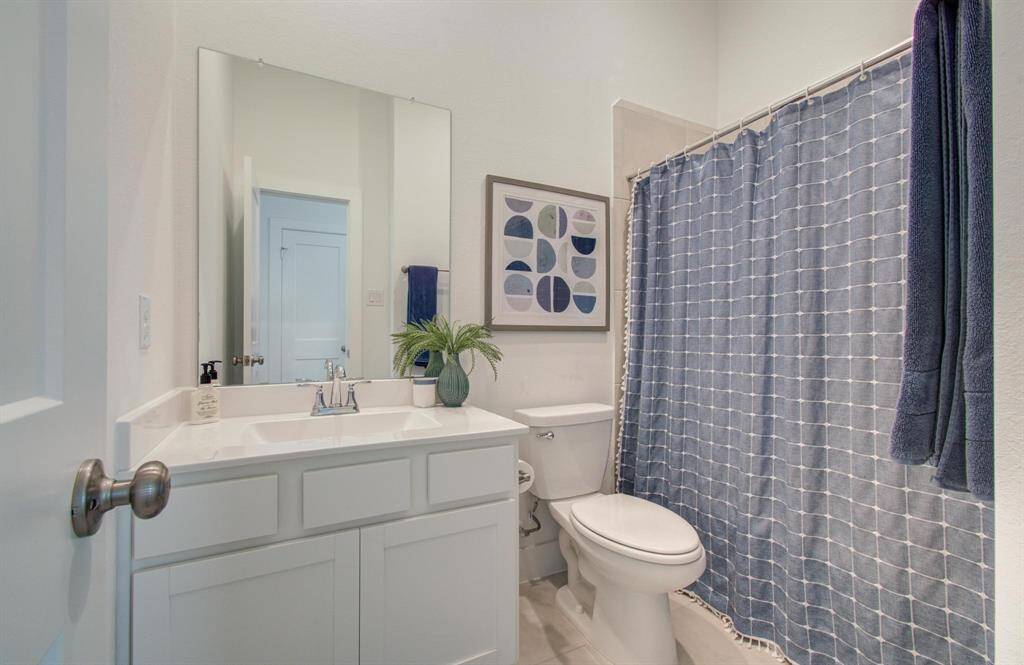 The secondary bath is beautiful with great storage, tile surround tub, and Quartz counters.