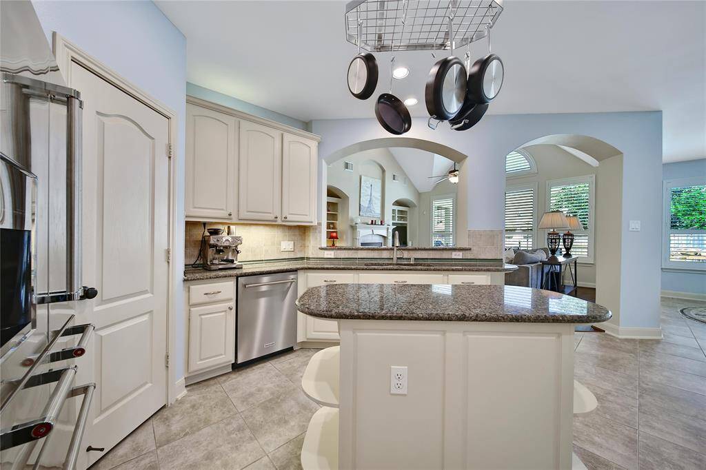 This island kitchen is a chef's delight. The island offers storage and prep space and there's a serving/seating bar overlooking the family room.