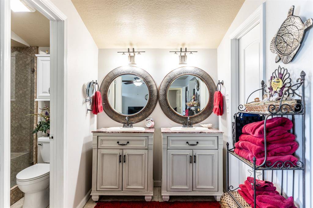 Primary bathroom with dual vanities and large walk-in closet