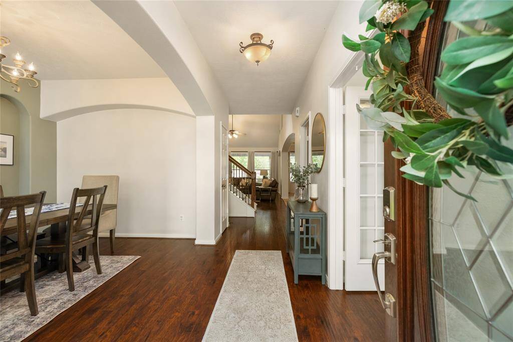 From the moment you step through the front door, you're greeted by timeless elegance and thoughtful design. Rich hardwood floors, soft natural light, and graceful architectural details create a warm, inviting ambiance that carries throughout the home. The arched entryway opens to a spacious dining area and offers a peek into the cozy living room beyond—each space beautifully maintained and ready to welcome you home.