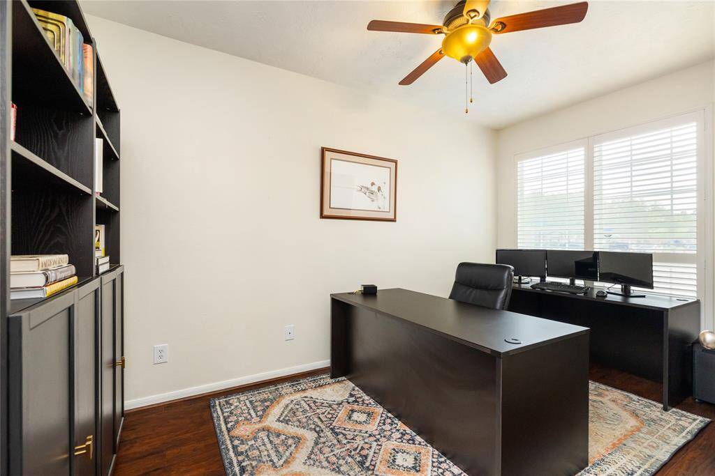 Bathed in natural light from large windows, this dedicated home office offers a quiet and refined space for work or study. Thoughtfully designed with hardwood floors and a ceiling fan for year-round comfort, it’s a perfect blend of function and timeless style.