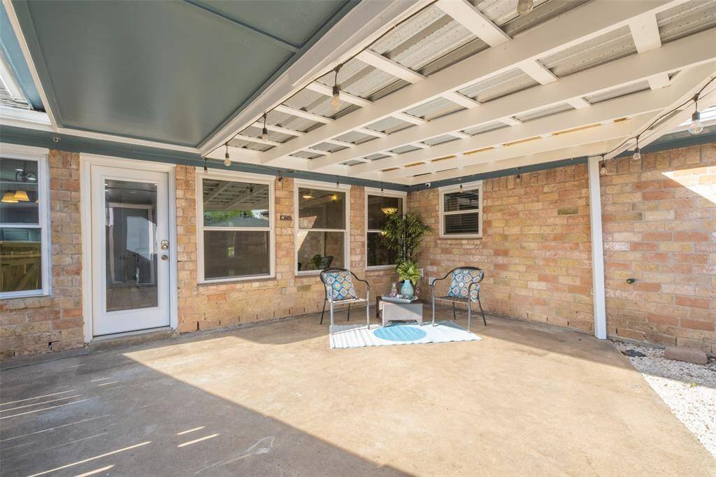 Cozy covered patio with a concrete floor, and brick, perfect for outdoor relaxation. Large windows, allowing for plenty of natural light.