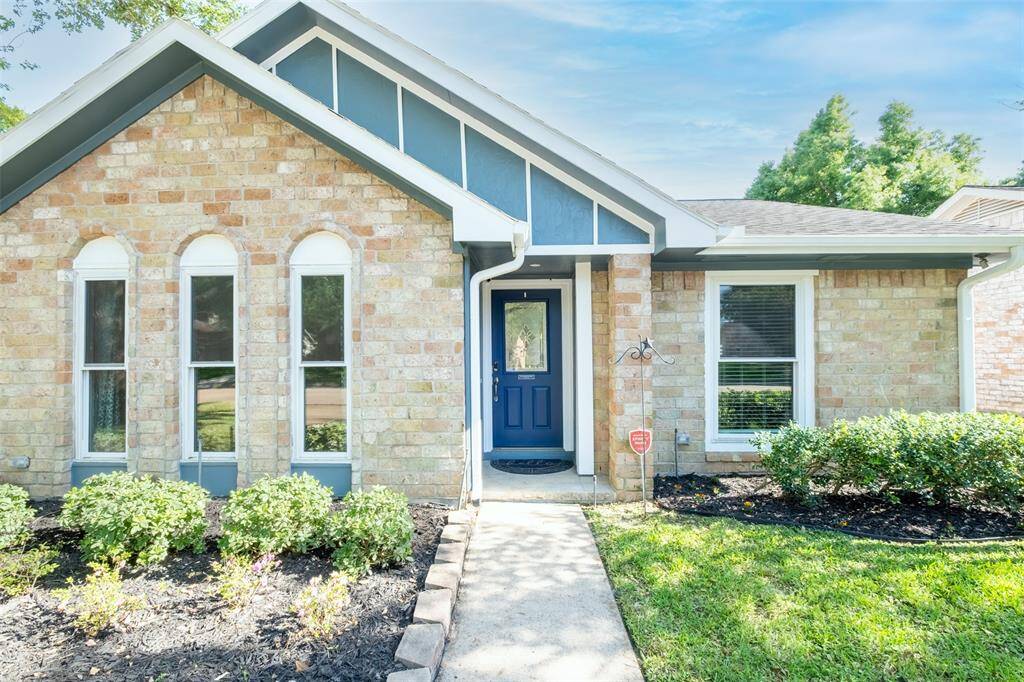 Classic brick exterior, a well-maintained front yard with mature trees.