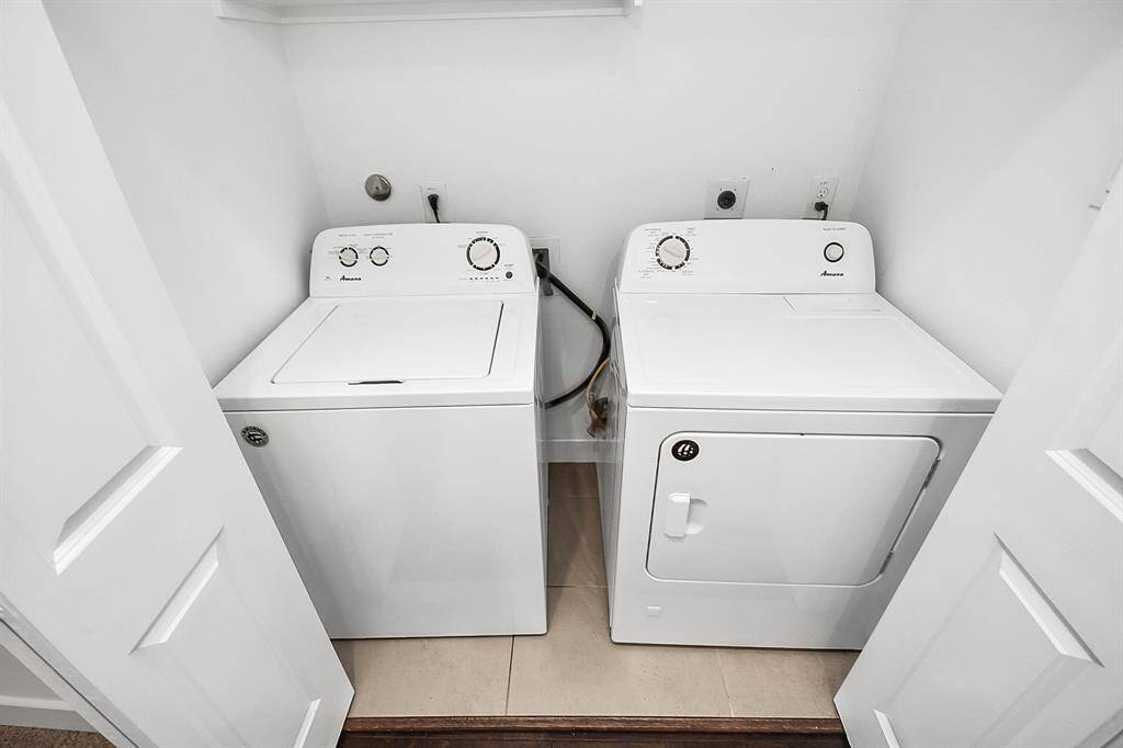 Utility room in the house with washer and dryer included
