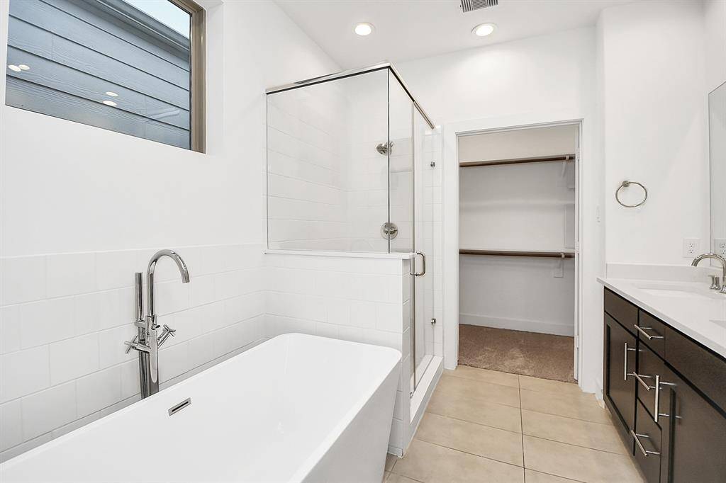 Big primary bathroom with double sinks, separate soaking tub, and walk in shower