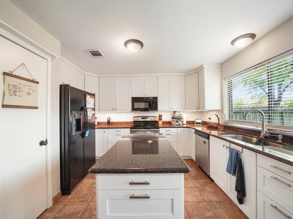 The kitchen, thoughtfully updated in 2024, is a culinary enthusiast's dream. Elegant new cabinets provide abundant storage space, while updated lighting illuminates the area, creating a bright and inviting atmosphere.