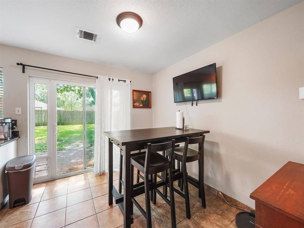 Adjacent to the kitchen, the breakfast area provides a seamless transition to the expansive backyard through sliding glass doors.