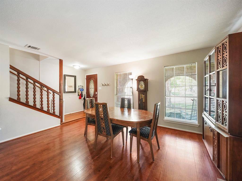 Step into a light-filled dining space, where expansive windows bathe the room in natural light. The gentle wall color harmonizes beautifully with the warm, wood-look laminate flooring, creating an inviting atmosphere for meals and gatherings. A perfect spot to enjoy your daily meals.