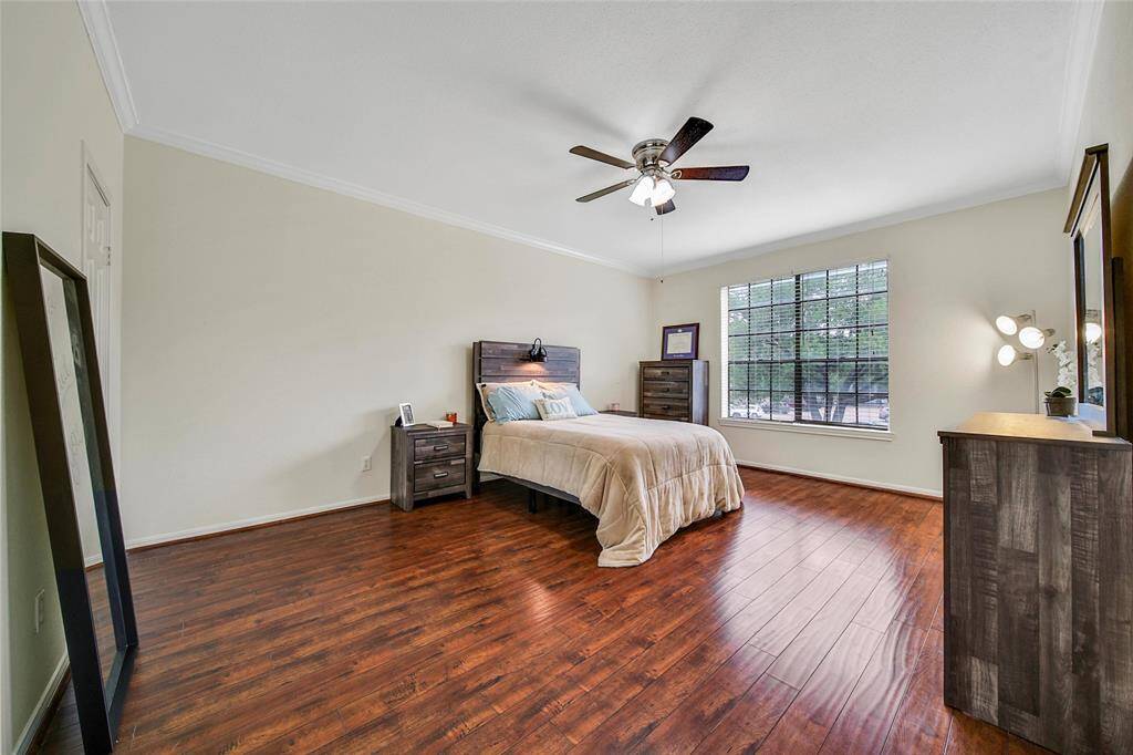 The primary suite is located at the back of the unit for privacy. This expansive space offers ample room for a large bedroom suite as well as a desk, sitting area or fitness area. It offers tree lined views, a ceiling fan for additional temperature control, a large walk in closet and an ensuite bath. Note the wood look flooring, fresh neutral paint and crown molding continue in the bedrooms. There is no carpet in this property!