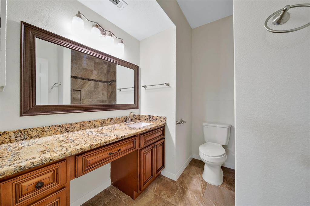 The second bathroom was remodeled to offer a shower/tub combination and an extended vanity with granite top matching the kitchen cabinetry. The extended vanity is accented by a beautiful framed mirror.