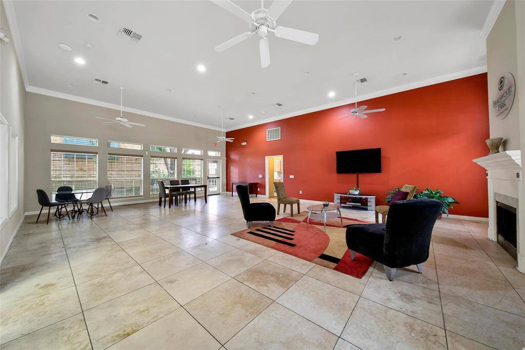 The clubhouse features a large open space with chairs and a television.