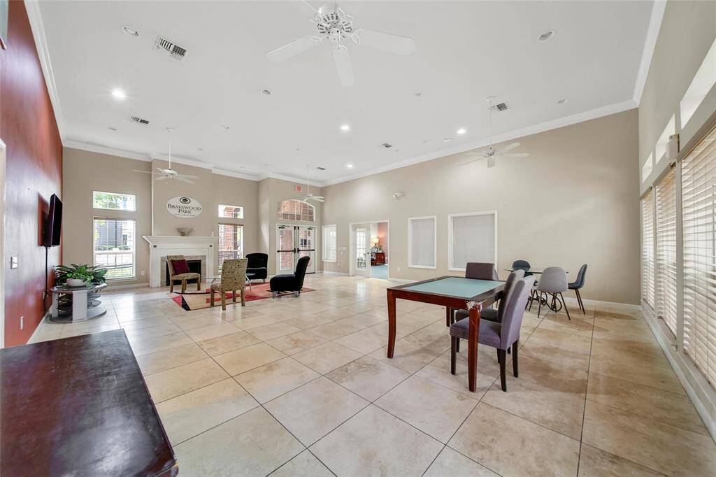 The clubhouse features a large open space with chairs and a television.