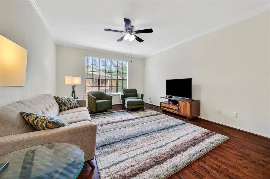 The living room offers space for a large sectional and lounge chairs and is the perfect gathering space for movie night, game night, or to simply unwind in the comfort of your own home after a long day. Note the blinds for light and privacy control, which are included throughout the property.