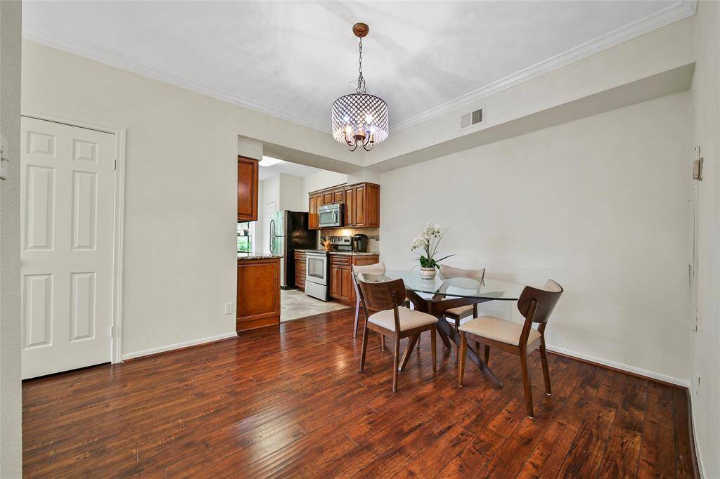 A dazzling chandelier anchors the formal dining room, lending elegance to the space. The dining room opens to the kitchen, facilitating staying connected when cooking and entertaining. A large closet to the left of the kitchen offers additional storage space.