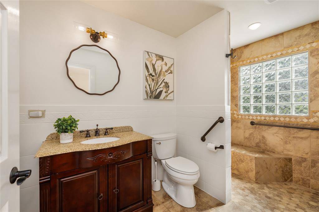 Primary bathroom downstairs has a large walk-in shower with bench seating