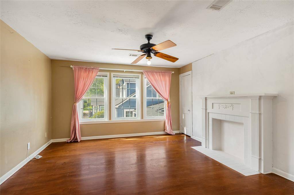 Quaint garage apartment living room with mock fireplace and original hardwood floors
