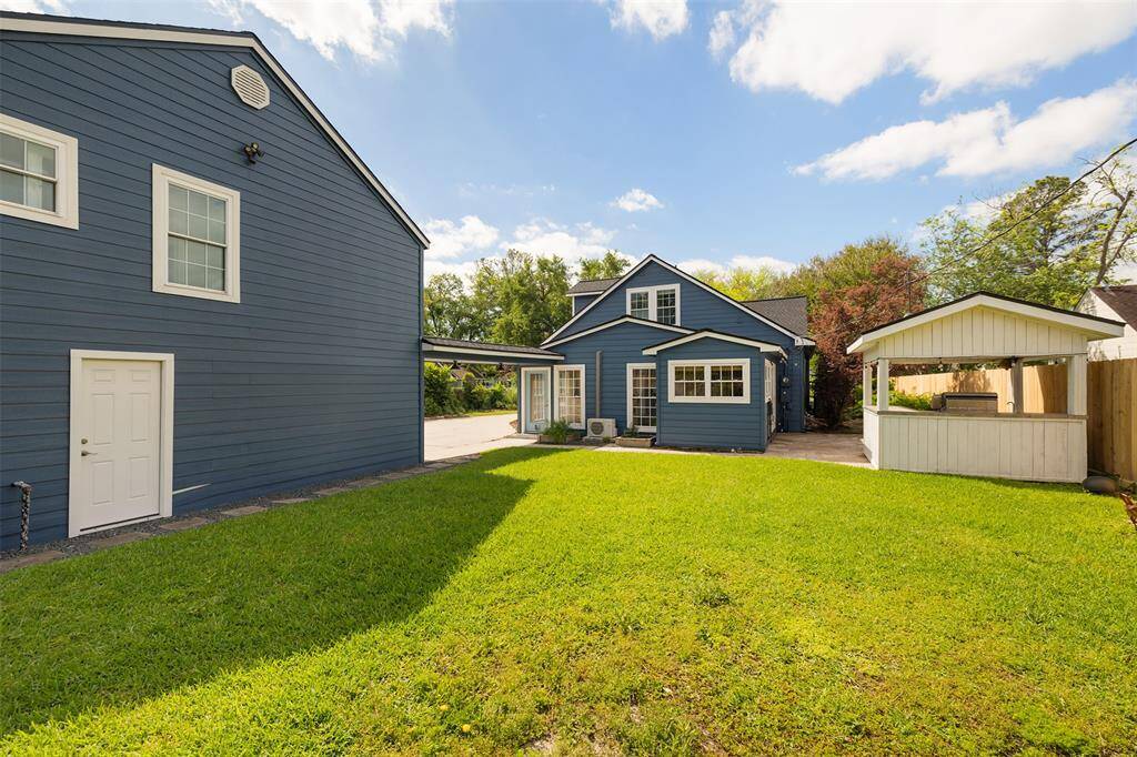 A view from the spacious backyard to the main house and outdoor kitchen