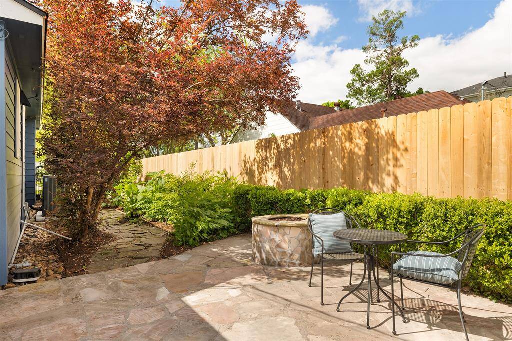 Side yard with pathway to the front, fire pit and covered outdoor kitchen