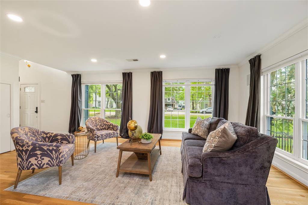 Bright and inviting living room with large windows, elegant seating, and a cozy atmosphere. Perfect for relaxing and entertaining.